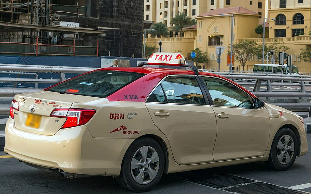تاكسي دبي باللون البيج والأحمر